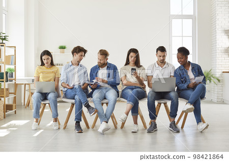 Group of students using modern digital devices at meeting Group of students using modern digital devices at meeting 98421864