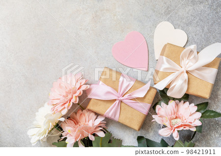 Valentine's Day background with gifts, beautiful flowers and hearts. Valentine's day, Womans day, wedding, birthday or mothers day greeting card. View from above. Valentine's Day background with gifts, beautiful flowers and hearts. Valentine's day, Womans day, wedding, birthday or mothers day greeting card. View from above. 98421911