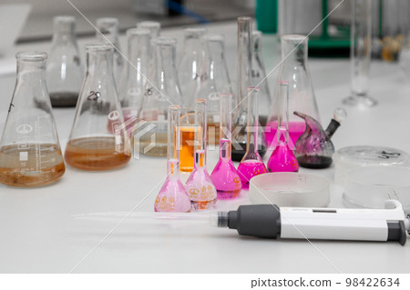 Composition of laboratory material with colored liquids in realistic glass pots Composition of laboratory material with colored liquids in realistic glass pots 98422634