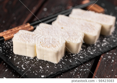 Asian dessert maki sushi close-up - Roll with fruits and cream cheese with coconut flakes Asian dessert maki sushi close-up - Roll with fruits and cream cheese with coconut flakes 98423083