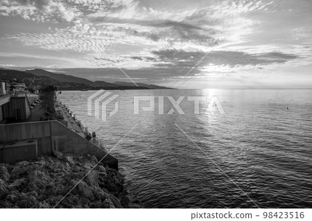 Monaco ambankment of French Riviera and panoramo in direction of Italy in Mediterranean Sea . Fantastic landscape with tall palm trees with sunrays and reflections Monaco ambankment of French Riviera and panoramo in direction of Italy in Mediterranean Sea . Fantastic landscape with tall palm trees with sunrays and reflections 98423516