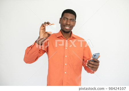 Portrait of happy young man with smartphone showing credit card Portrait of happy young man with smartphone showing credit card 98424107