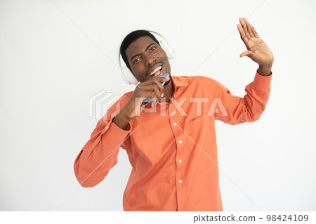 Portrait of happy young man in headphones singing in smartphone Portrait of happy young man in headphones singing in smartphone 98424109