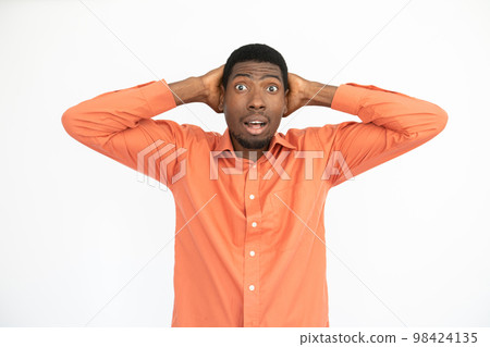 Portrait of surprised young man posing with hands behind head Portrait of surprised young man posing with hands behind head 98424135