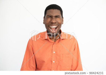Portrait of frustrated young man screaming over white background Portrait of frustrated young man screaming over white background 98424231