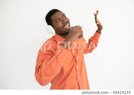 Portrait of young man listening to music and recording voice Portrait of young man listening to music and recording voice 98424235