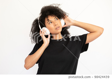 Portrait of concentrated young woman listening to music Portrait of concentrated young woman listening to music 98424439