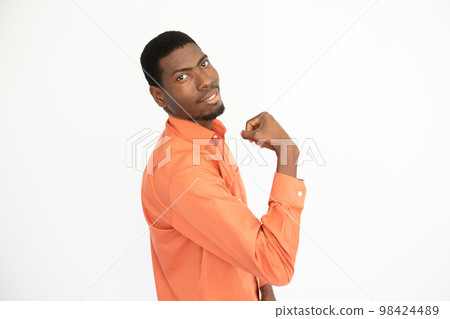 Portrait of happy young man showing bicep and smiling 98424489