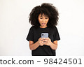 Portrait of excited young woman reading message on smartphone 98424501