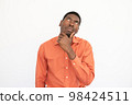 Portrait of thoughtful young man touching chin 98424511
