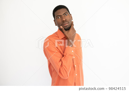 Portrait of confident young man touching chin Portrait of confident young man touching chin 98424515