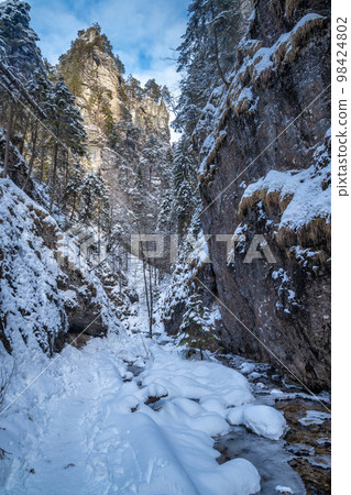 Snowy winter landscape with a tourist trail. Snowy winter landscape with a tourist trail. 98424802