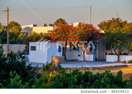 House with a blooming tree at sunset on the island of Rhodes. House with a blooming tree at sunset on the island of Rhodes. 98424813