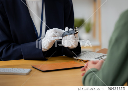 A woman appraising a watch 98425855