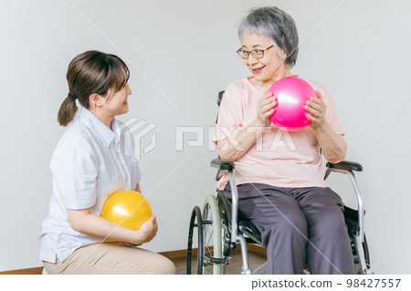 在療養院進行球類體操、鍛煉和康復的老年男性和女性，以及物理治療師、護理人員和培訓師 98427557