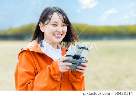 Young woman operating a drone Young woman operating a drone 98428114
