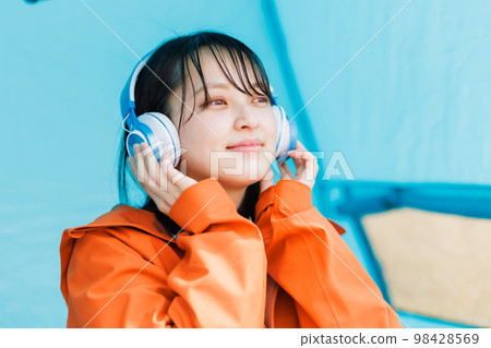 在帳篷裡放鬆的年輕女人 在帳篷裡放鬆的年輕女人 98428569