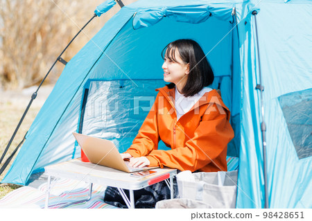 在帳篷裡放鬆的年輕女人 在帳篷裡放鬆的年輕女人 98428651