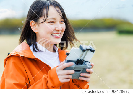 Young woman operating a drone 98428652