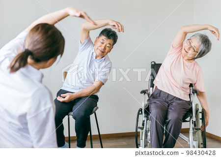 在療養院進行球類體操、運動和康復訓練的老年男性和女性,以及檢查他們健康狀況的工作人員 在療養院進行球類體操、運動和康復訓練的老年男性和女性,以及檢查他們健康狀況的工作人員 98430428