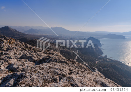View on Sudak, sea, mount and cape from the slope of Falcon Sokol mountain at morning . Crimea 98431224