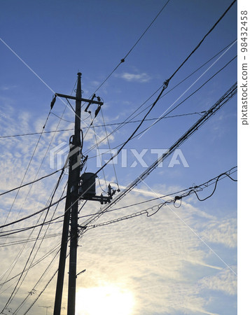 在藍天的早晨太陽和電線桿的剪影 98432458