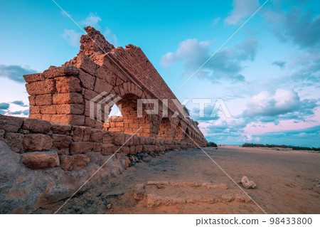 Aqueduct in ancient city Caesarea at sunset. Creative color 98433800