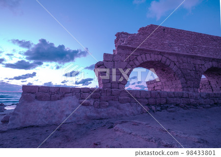 Aqueduct in ancient city Caesarea at sunset. Trendy purple color 98433801