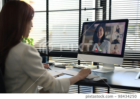 Rear view of female manager communicating by video conference on computer. Distant webinar, online negotiations concept 98434250