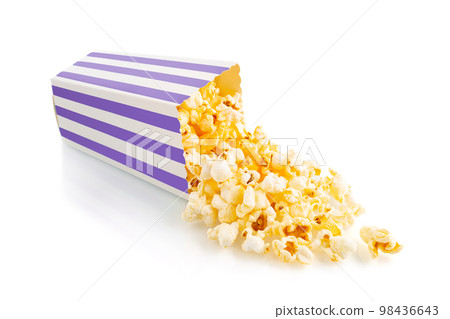 Tasty cheese popcorn falling out of a purple striped carton bucket, isolated on white background Tasty cheese popcorn falling out of a purple striped carton bucket, isolated on white background 98436643
