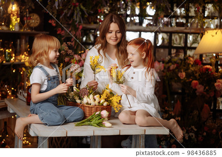 Two girls and a young mother make a bouquet 98436885