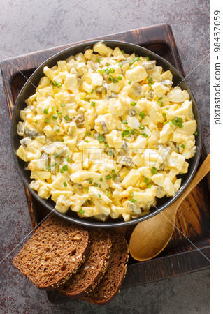 Eiersalat German Egg and Apple Salad served with bread closeup on the wooden board. Vertical top view Eiersalat German Egg and Apple Salad served with bread closeup on the wooden board. Vertical top view 98437059