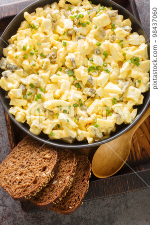 Eiersalat egg salad is a popular German dish that is served on bread closeup on the wooden board. Vertical top view 98437060