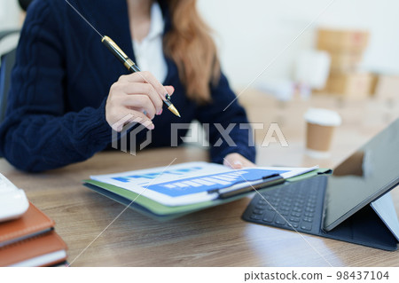Portrait of a thoughtful Asian businesswoman looking at financial statements and making marketing plans using a computer on her desk. Portrait of a thoughtful Asian businesswoman looking at financial statements and making marketing plans using a computer on her desk. 98437104