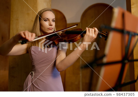 Full-length portrait of young female violinist playing fiddle Full-length portrait of young female violinist playing fiddle 98437305
