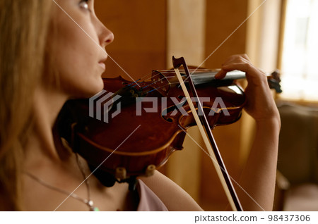 Beautiful young woman playing violin, closeup Beautiful young woman playing violin, closeup 98437306