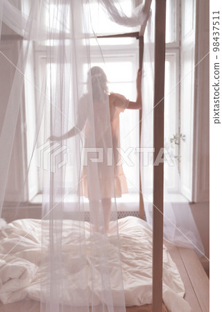 Beautiful woman. A gentle photo of a woman on the bed. View from back 98437511