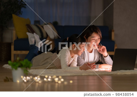 小學生和媽媽晚上躺在客廳看電腦 98438054