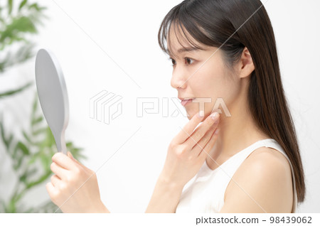 Woman looking in the mirror Woman looking in the mirror 98439062