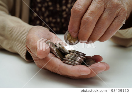 Retired elderly woman counting coins money and worry about monthly expenses and treatment fee payment. Retired elderly woman counting coins money and worry about monthly expenses and treatment fee payment. 98439120