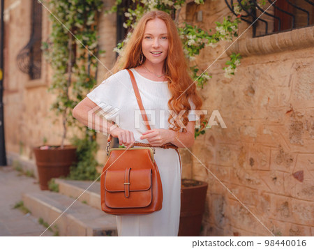 Happy woman tourist on blooming street of Antalya Happy woman tourist on blooming street of Antalya 98440016