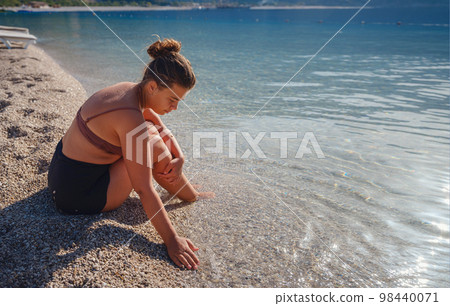 Cheerful woman enjoying the beach 98440071