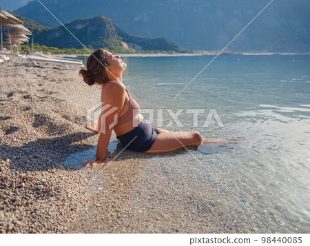 Cheerful woman enjoying the beach 98440085
