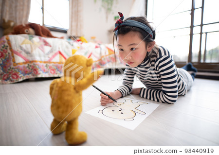 Little girl drawing a stuffed bear Little girl drawing a stuffed bear 98440919