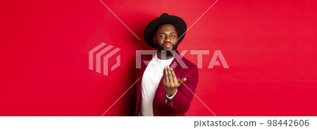 Handsome and masculine Black man asking come closer, luring to step forward, calling for you, standing over red background 98442606
