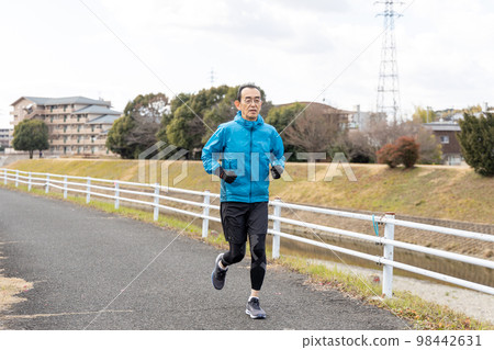 假日在河濱長廊上做慢跑愛好的老人 假日在河濱長廊上做慢跑愛好的老人 98442631