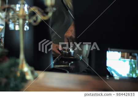 Motion blurred hand of barista pressing the coffee powder for making the fresh coffee with blurred foreground of coffee machine Motion blurred hand of barista pressing the coffee powder for making the fresh coffee with blurred foreground of coffee machine 98442633