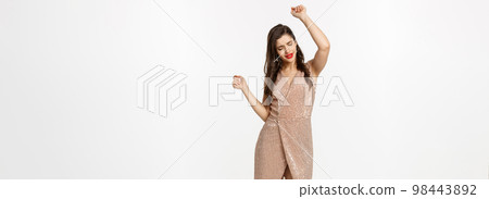 Christmas party and celebration concept. Full-length of attractive woman dancing in luxury dress, having fun, standing over white background Christmas party and celebration concept. Full-length of attractive woman dancing in luxury dress, having fun, standing over white background 98443892