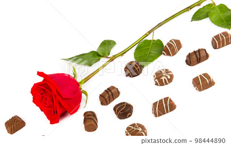 Chocolate candies and red rose isolated on white. Chocolate candies and red rose isolated on white. 98444890