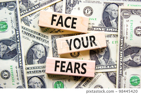 Face your fears and support symbol. Concept words Face your fears on wooden blocks on dollar bills. Beautiful background from dollar bills. Business and Face your fears quote concept. Copy space. 98445420